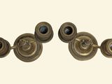 three antique brass candlesticks on a white background