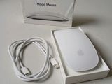 a white apple mouse sitting on a table next to a box