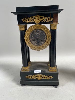 une paire de supports d'horloge noirs et dorés posés sur une surface blanche