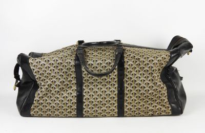 un sac marron et noir posé sur une surface blanche