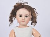 a doll that is wearing a white dress and a bracelet