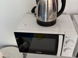 un micro-ondes sur lequel est posée une théière