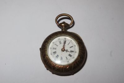 une petite montre de poche en or avec des chiffres romains
