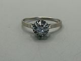 a close up of a diamond ring on a white surface
