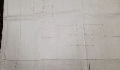 un gros plan sur un morceau de lin blanc orné de points de couture