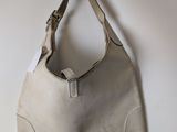 a white purse hanging on a hook on a wall