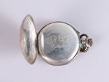 a silver pocket watch on a white surface