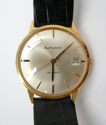une montre-bracelet en or avec un bracelet en cuir noir