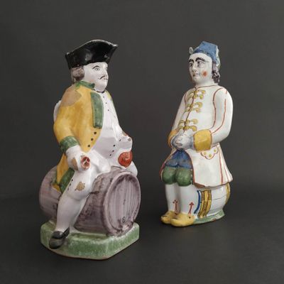 pair of ceramic figurines of a man and a woman sitting on a barrel