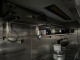 a kitchen with stainless steel shelves and pots on the wall