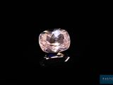 a close up of a pink diamond on a black surface