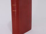 an old red book sitting on top of a white surface