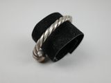 un gros plan d'une bague posée sur une surface blanche, avec un anneau noir