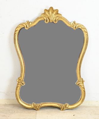 a gold framed mirror sitting on top of a wooden floor