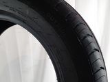 a close up of a tire on a white surface with a white curtain in the background
