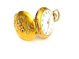 une petite montre de poche en or ornée d'un motif de feuille