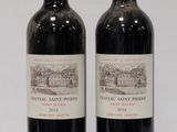 two bottles of red wine sitting next to each other on a table