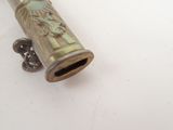 a small metal object on a white surface with a white background