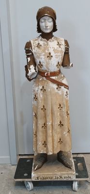 une statue représentant une femme portant un chapeau et une robe