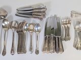 a lot of silver spoons and knives on the table