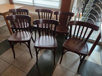 quatre chaises en bois placées devant une fenêtre