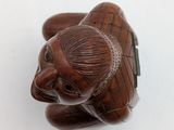 a small elephant figurine sitting on top of a white surface