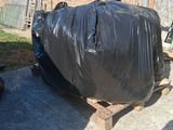 a pile of garbage on a pallet next to a brick wall