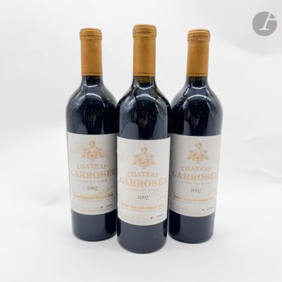 trois bouteilles de vin rouge posées l'une à côté de l'autre sur une surface blanche