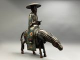 bronze statue of a woman riding a horse with a hat on her head