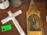 a wooden table with a cross, a candle, and other items on it