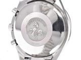 the watch is silver in color and has a logo on the face