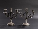 pair of silver plated candlesticks on stand against a black background