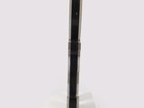 a black and silver pen sitting on top of a white stand