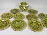 six green plates with decorative designs on them on a white surface