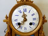 une horloge en or avec des chiffres romains bleus et blancs