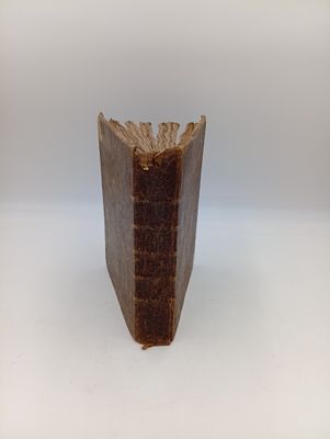 un livre brun posé sur une surface blanche