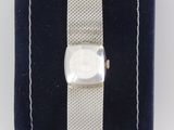 an image of a wrist watch with a silver band on a blue velvet case