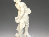 an antique statue of a man with a basket on his back