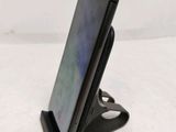 a close up of a cell phone on a stand on a table