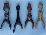 quatre figurines en bois sont alignées sur une surface blanche