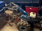a blue tractor that is parked in a garage