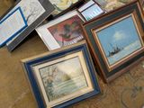 many framed pictures on the floor of a room