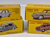 three toy cars are sitting in boxes on a white surface