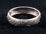 an image of a close up of a silver ring on a black surface