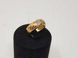 a gold and diamond ring on top of a black ring holder