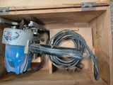 une boîte contenant une perceuse et un cordon d'alimentation