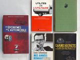 plusieurs livres posés sur une table blanche, avec une voiture en arrière-plan