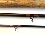 a close up of two fishing rods on a white surface
