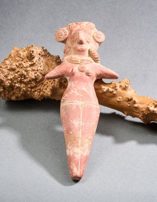 figurine représentant une femme tenant un morceau de bois sur une table