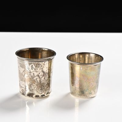 two silver cups sitting next to each other on a table